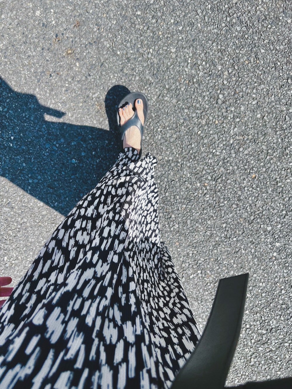 ブラック系のサンダル、ブラック系のワンピース、ブラック系のバッグを着用したレディースの夏コーディネートの3枚目の写真