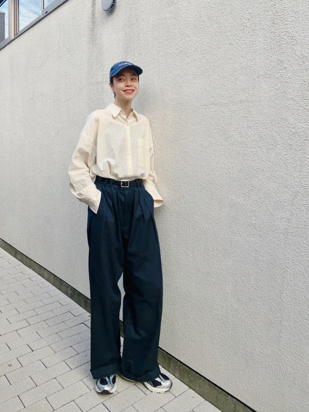 ブルー系のスラックス、ベージュ系のシャツ/ブラウス、ブラック系のスニーカーを着用したレディースの秋コーディネートの2枚目の写真