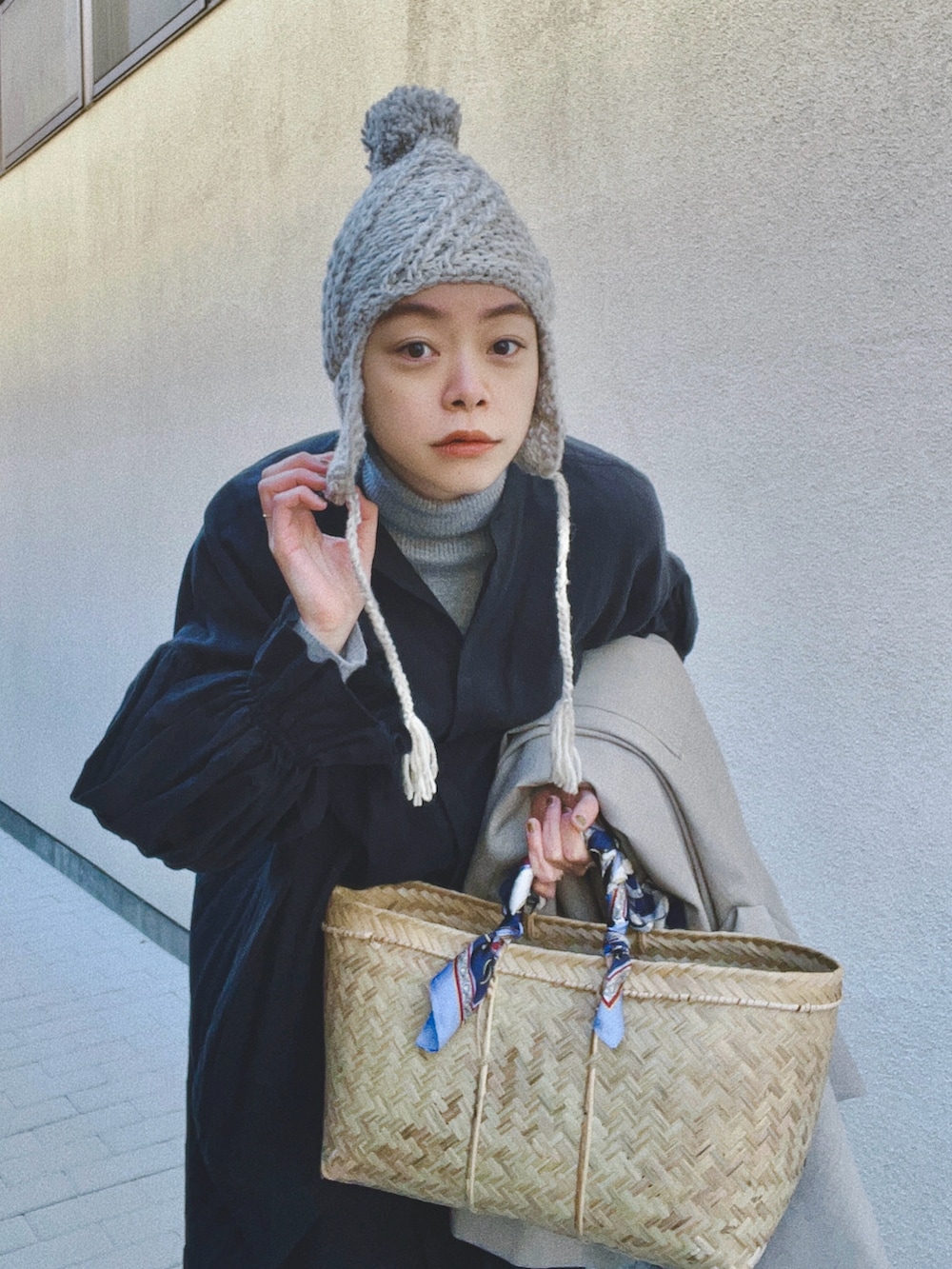 グレー系のニット/セーター、ブラック系のシャツワンピース、ベージュ系のジャケット/アウターを着用したレディースの冬コーディネートの2枚目の写真