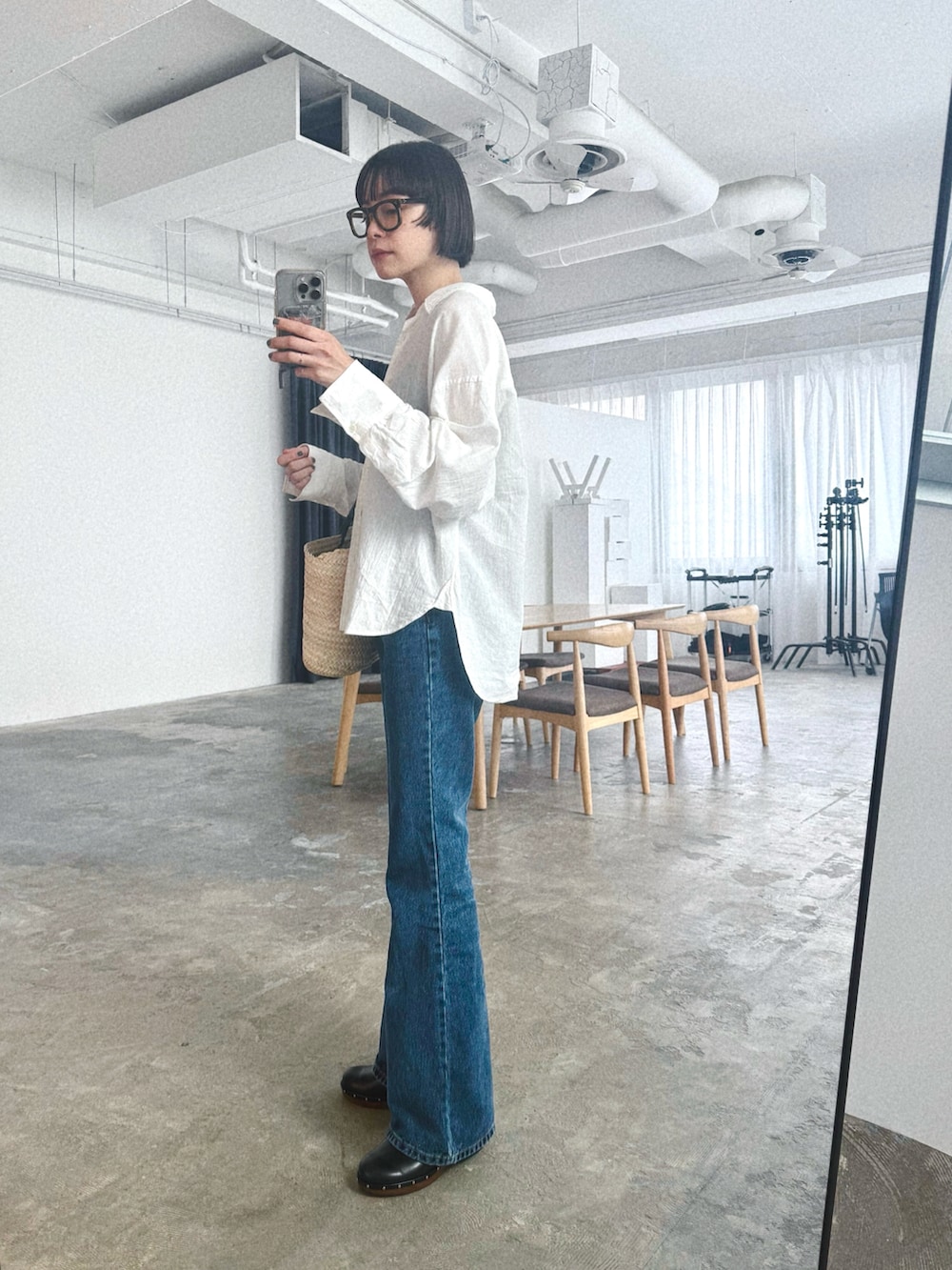 ブルー系のデニムパンツ、ベージュ系のかごバッグ、ホワイト系のシャツ/ブラウスを着用したレディースの夏コーディネートの2枚目の写真