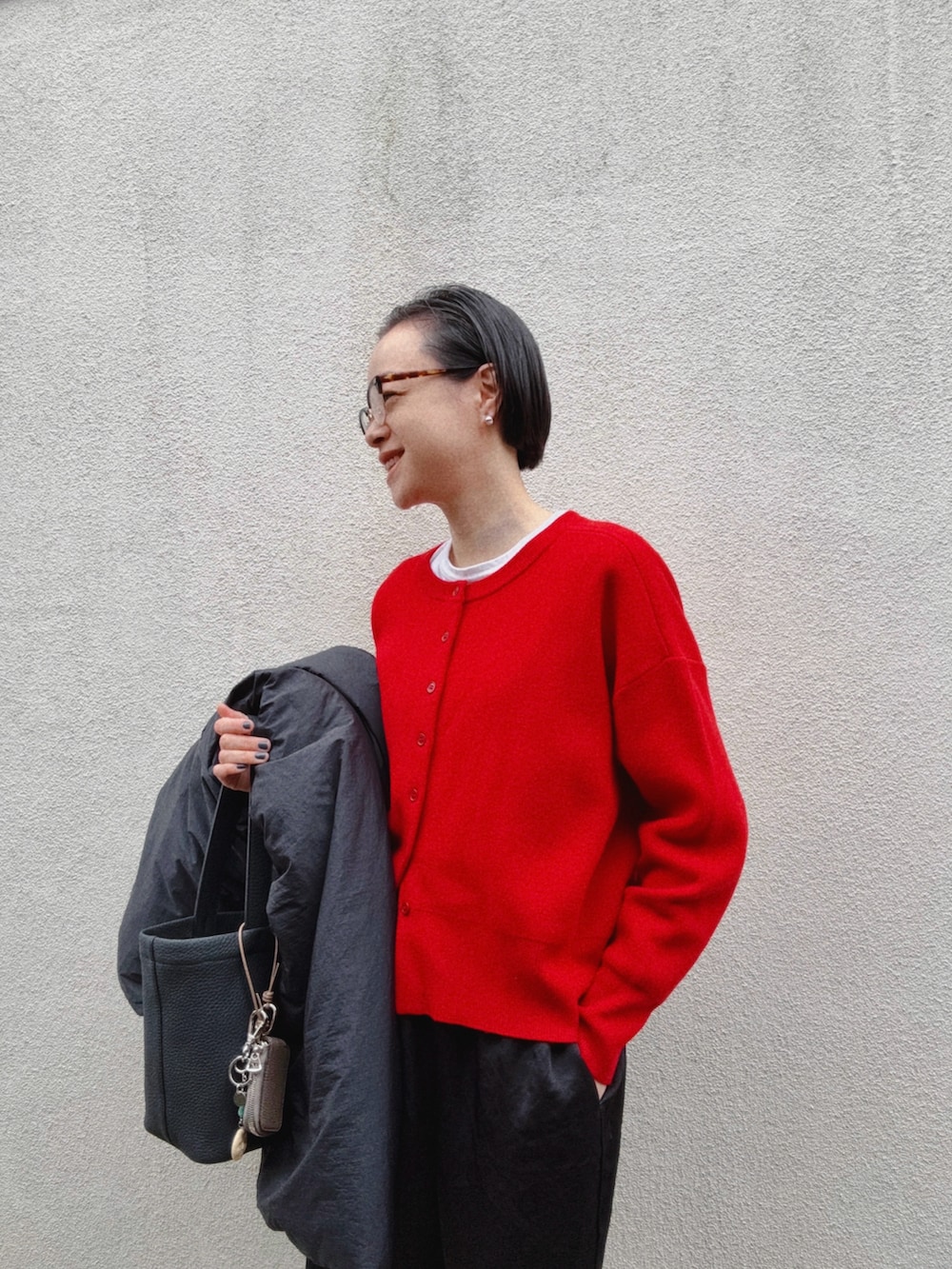 レッド系のカーディガン/ボレロ、ホワイト系のTシャツ/カットソー、ブラック系のバッグを着用したレディースの冬コーディネートの2枚目の写真