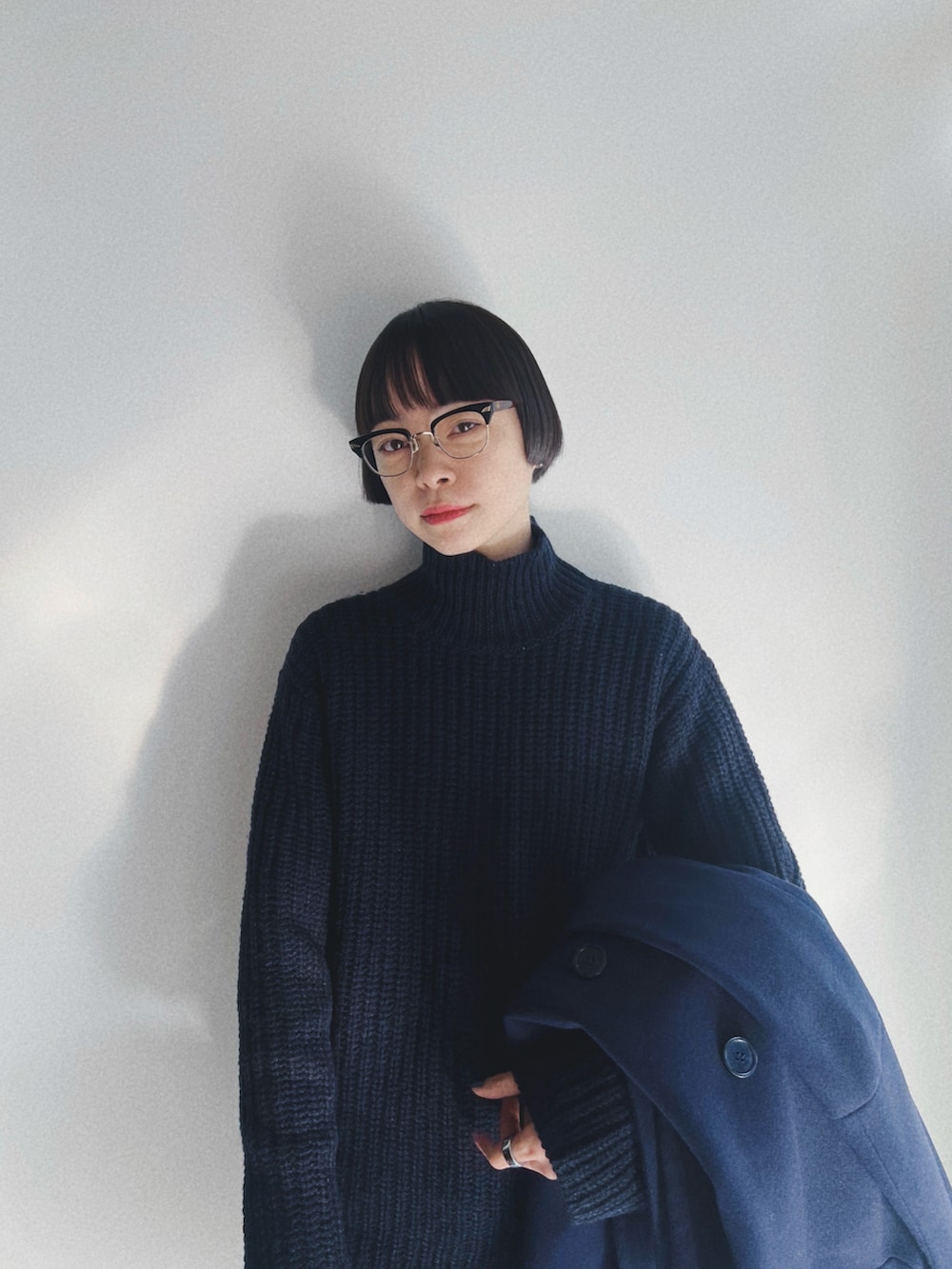 ブラック系のドレスシューズ、ブルー系のその他アウター、ブルー系のニット/セーターを着用したレディースの冬コーディネートの2枚目の写真