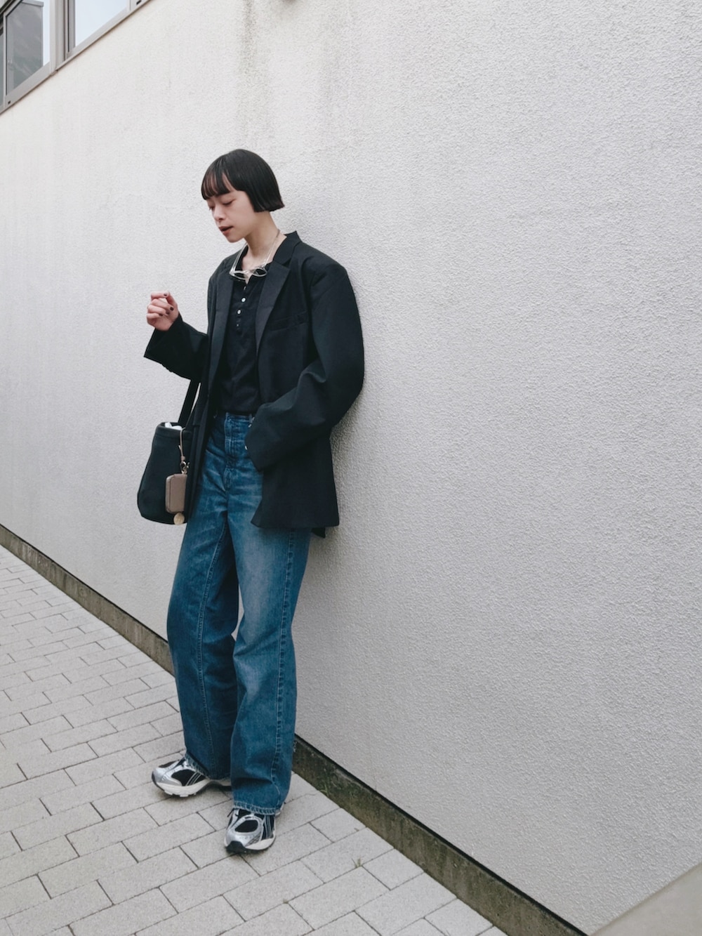 ブルー系のデニムパンツ、ブラック系のテーラードジャケット、ブラック系のTシャツ/カットソーを着用したレディースの冬コーディネートの2枚目の写真