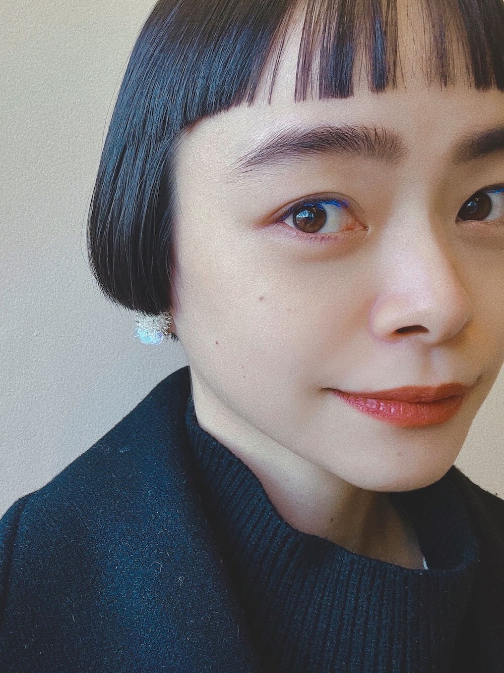 ブラック系のピーコート、ブラック系のベスト、ホワイト系のワンピースを着用したレディースの冬コーディネートの2枚目の写真