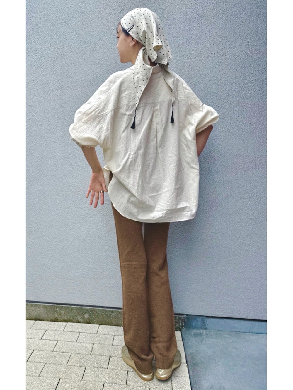 ベージュ系のシャツ/ブラウス、ブラウン系のパンツ、ゴールド系のスリッポンを着用したレディースの秋コーディネートの2枚目の写真