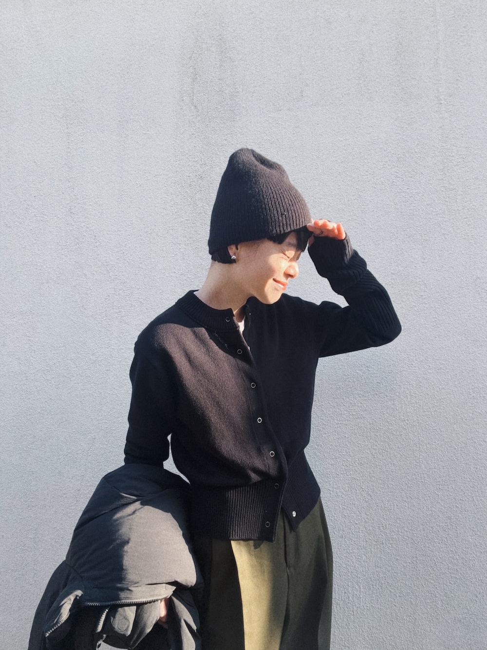 ブラック系のカーディガン/ボレロ、グリーン系のスラックス、グレー系のスニーカーを着用したレディースの春コーディネートの2枚目の写真