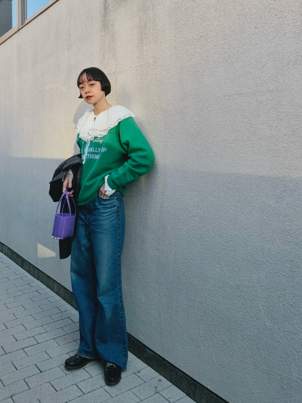 グリーン系のスウェット、ホワイト系のシャツ/ブラウス、ブルー系のデニムパンツを着用したレディースの冬コーディネートの2枚目の写真