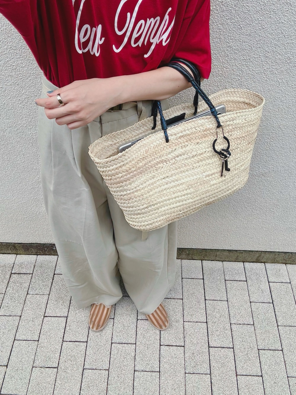 レッド系のTシャツ/カットソー、グリーン系のその他パンツ、ベージュ系のかごバッグを着用したレディースの秋コーディネートの2枚目の写真