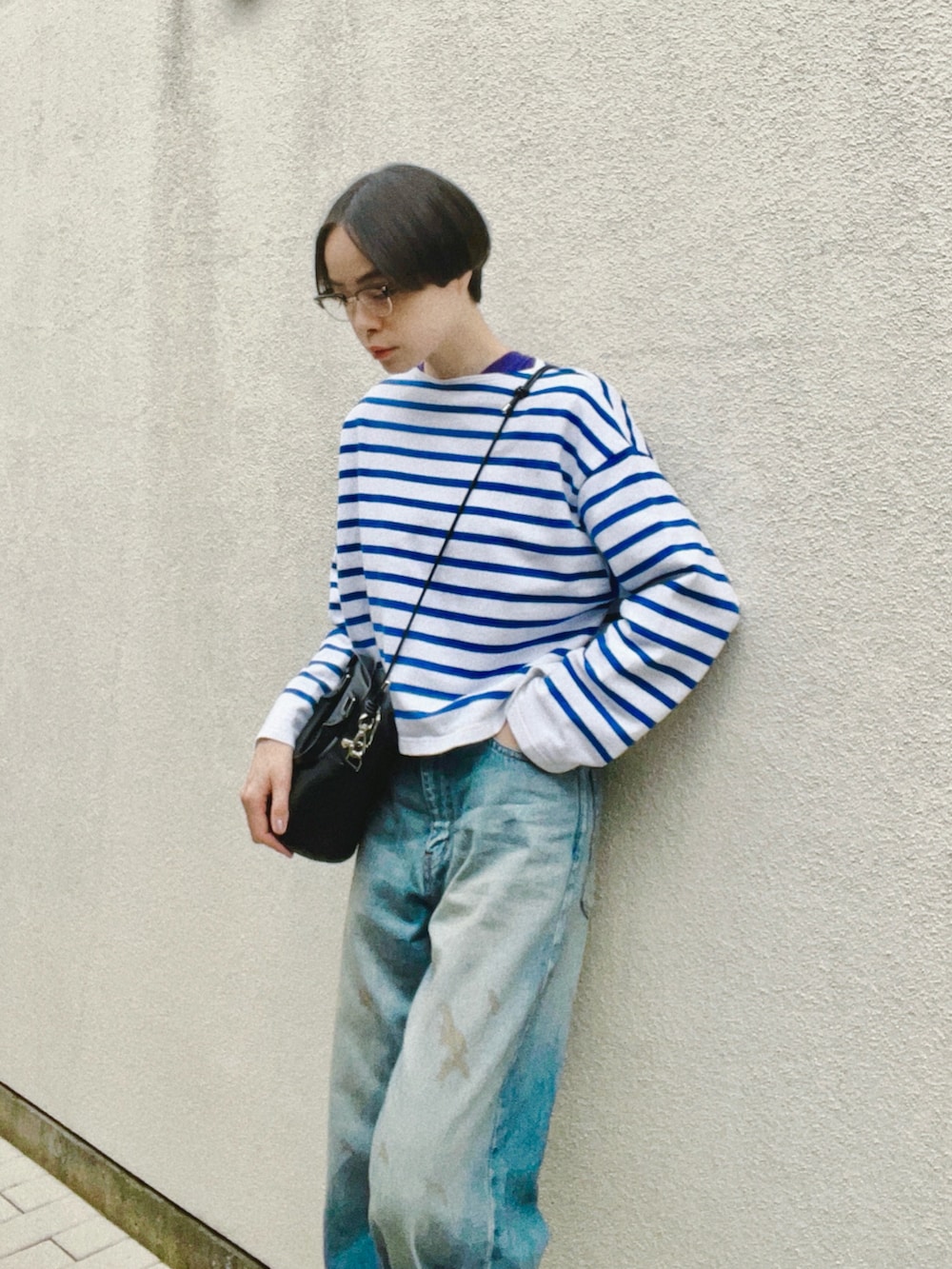 ブルー系のデニムパンツ、ブルー系のトップス、ブラック系のショルダーバッグを着用したレディースの春コーディネートの3枚目の写真