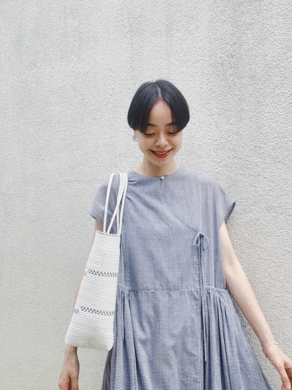 ブルー系のワンピース、ホワイト系のスカート、ホワイト系のサンダルを着用したレディースの春コーディネートの3枚目の写真