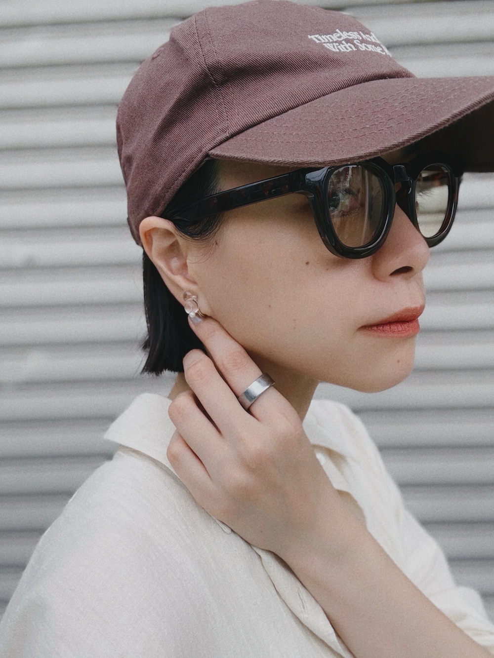 ホワイト系のデニムパンツ、ベージュ系のシャツ/ブラウス、グレー系のサンダルを着用したレディースの夏コーディネートの2枚目の写真