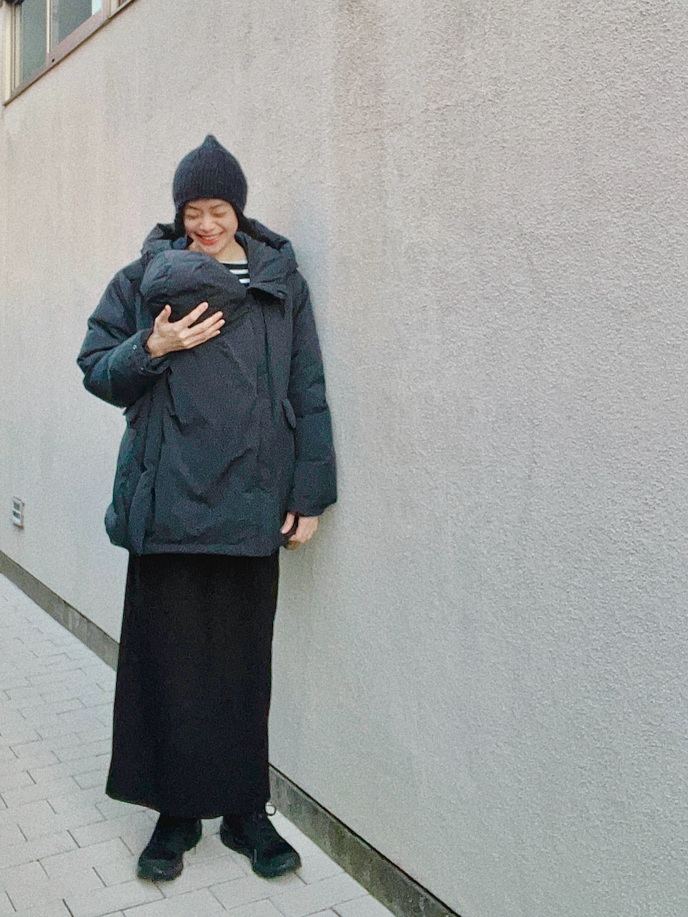 ブラック系のダウンジャケット/コート、ブラック系のスカート、ブラック系のスニーカーを着用したレディースの冬コーディネートの2枚目の写真