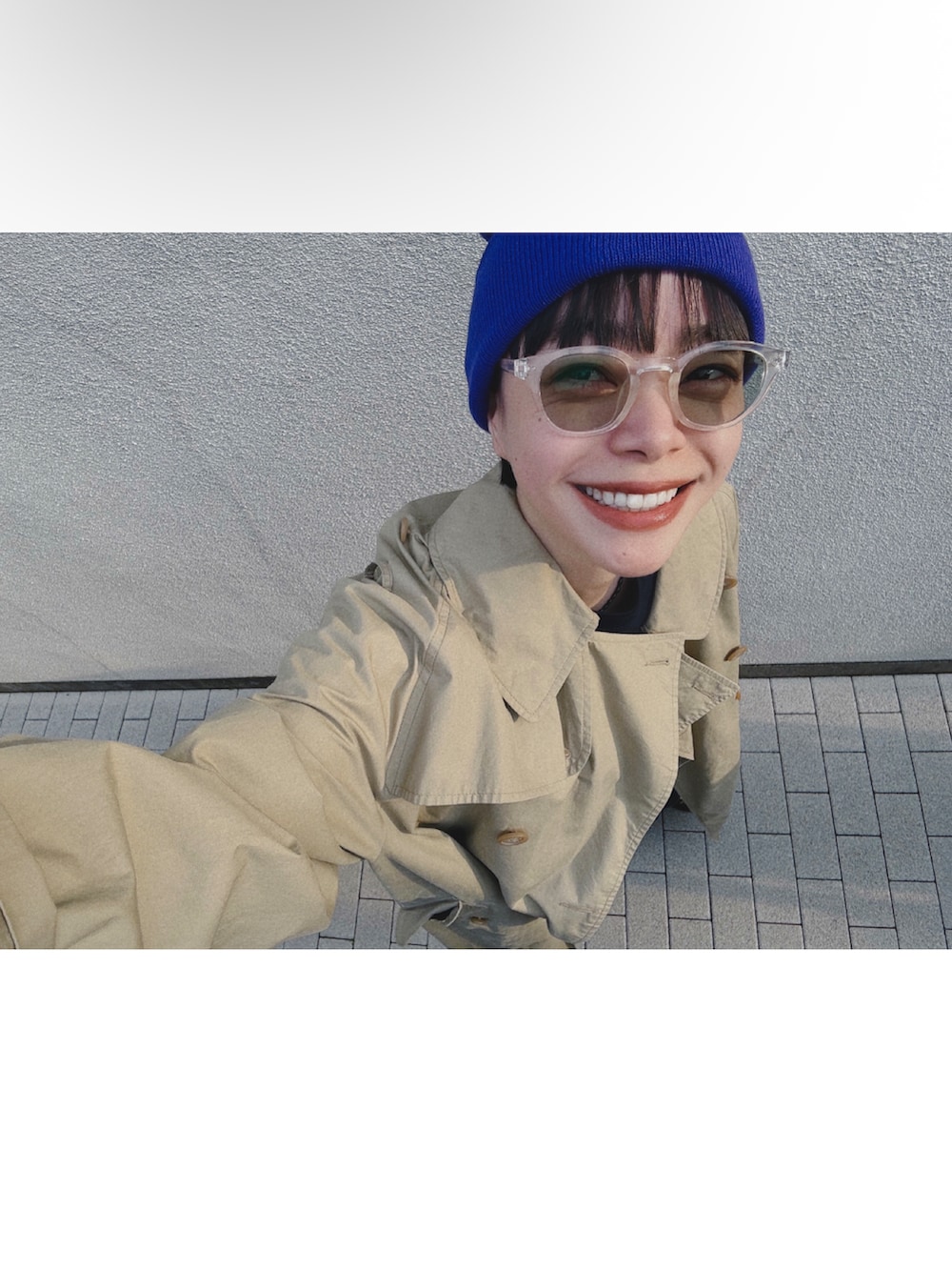 ベージュ系のトレンチコート、ブルー系のデニムパンツ、ブラウン系のローファーを着用したレディースの春コーディネートの2枚目の写真