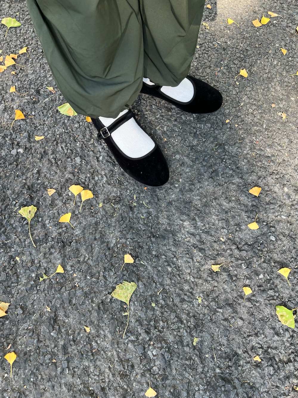 ブラック系のトップス、ブラック系のバックパック/リュック、グリーン系のカーゴパンツを着用したレディースの秋コーディネートの2枚目の写真