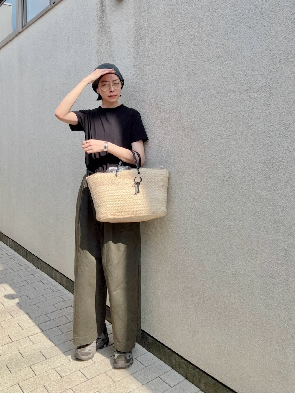 ベージュ系のかごバッグ、グリーン系のその他パンツ、グレー系のスニーカーを着用したレディースの夏コーディネートの2枚目の写真