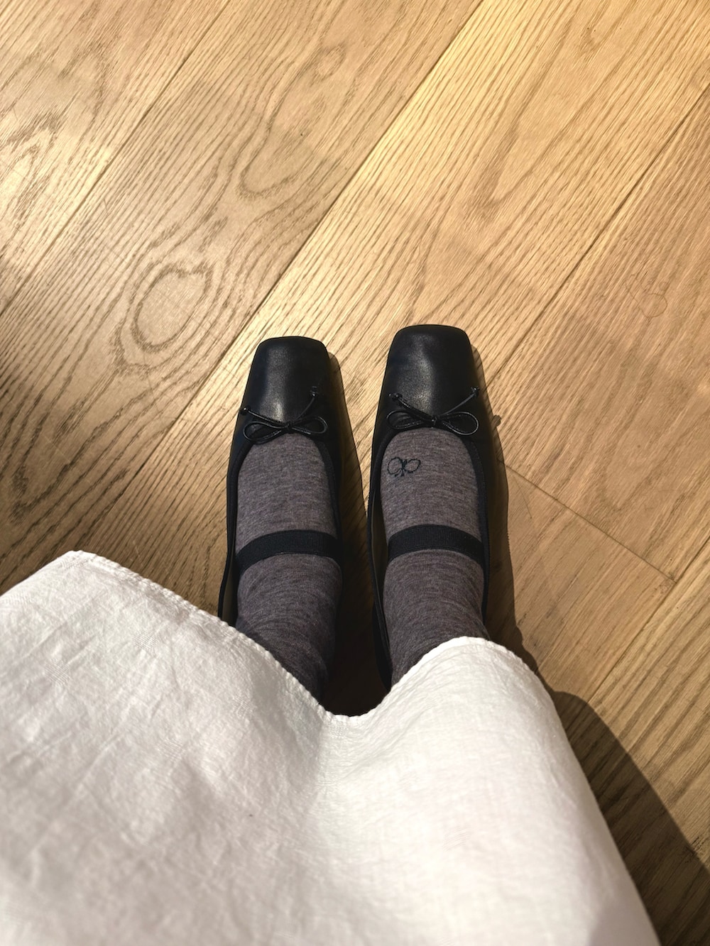 ホワイト系のワンピース/ドレス、ブラック系のジャケット/アウター、ベージュ系のかごバッグを着用したレディースの春コーディネートの4枚目の写真