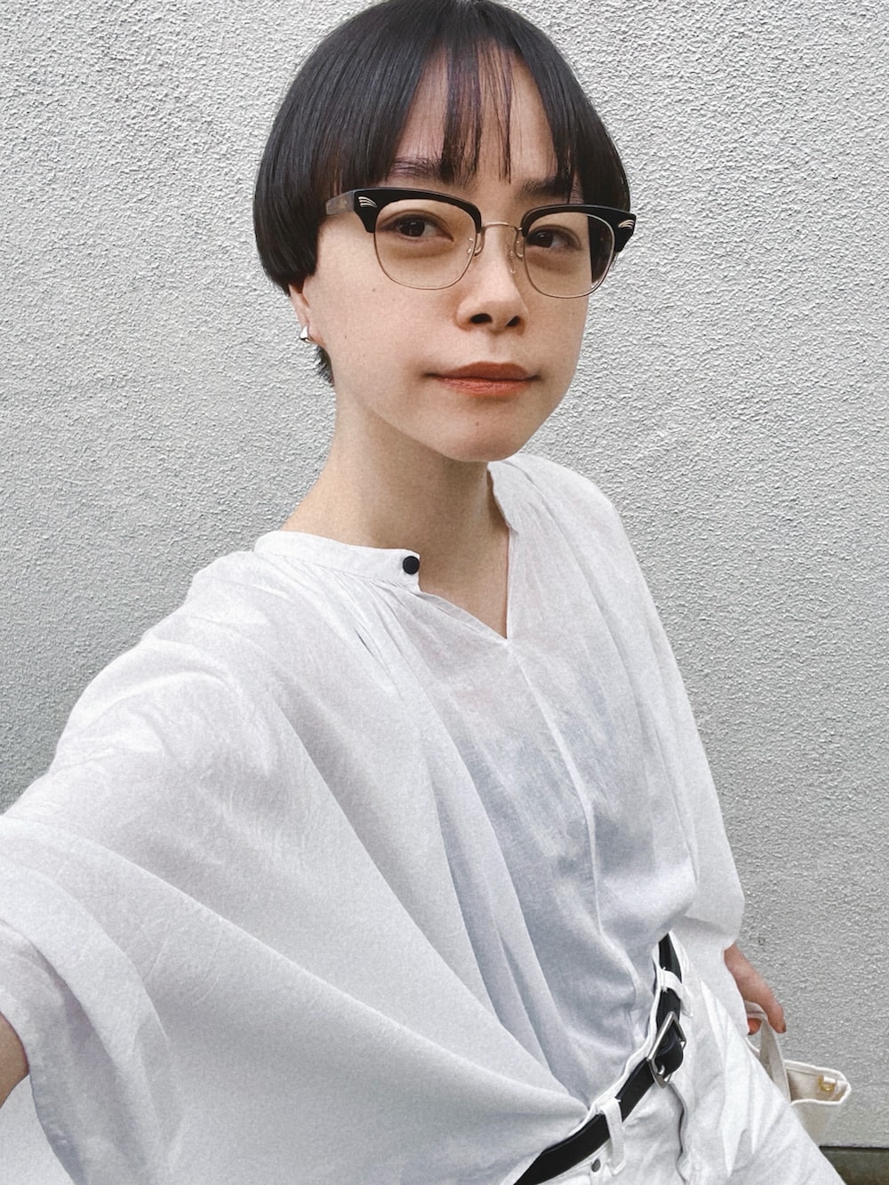 ブラック系のサンダル、ホワイト系のシャツ/ブラウス、ホワイト系のデニムパンツを着用したレディースの夏コーディネートの3枚目の写真