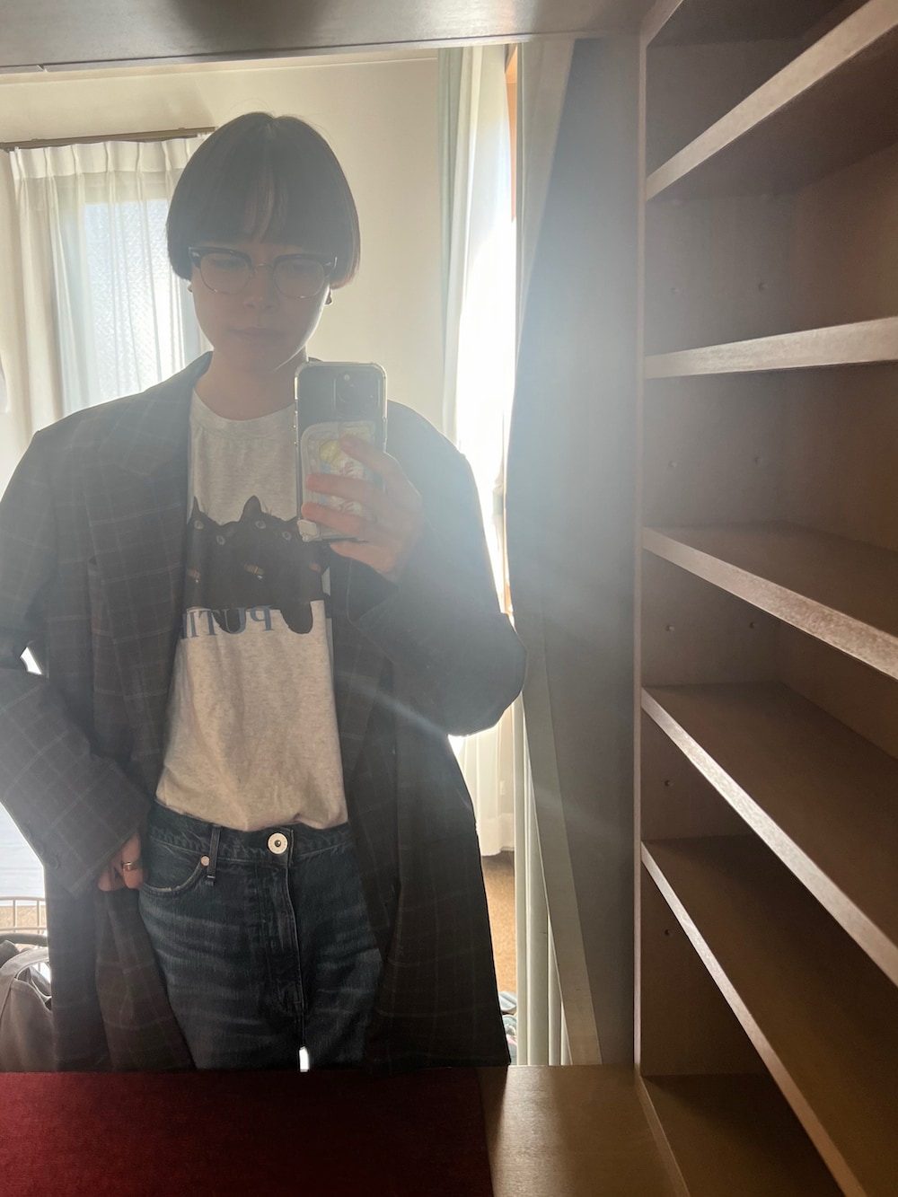 ブラウン系のテーラードジャケット、ブルー系のデニムパンツ、ブラック系のバッグを着用したレディースの秋コーディネートの3枚目の写真