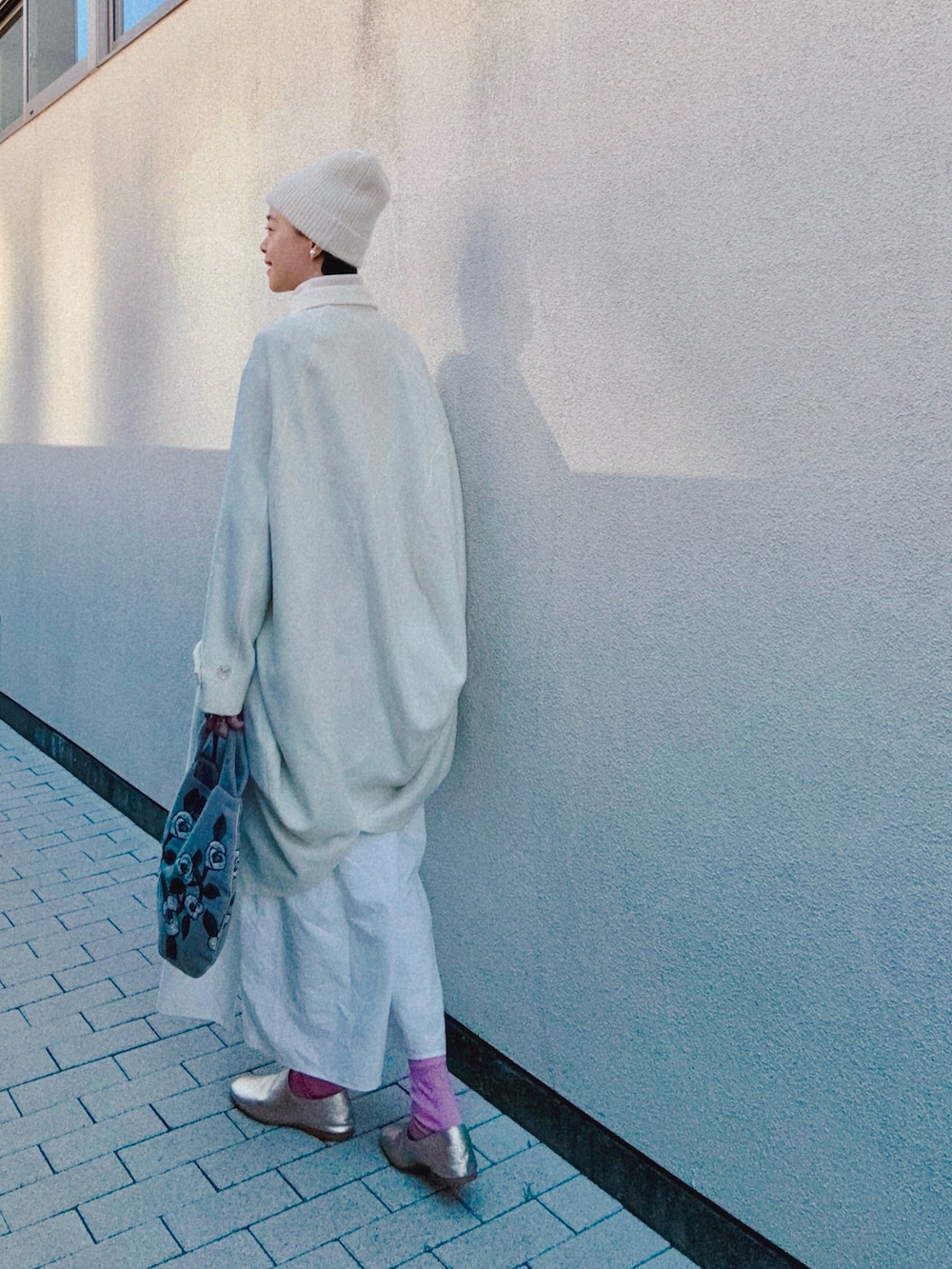 ホワイト系のジャケット/アウター、ホワイト系のワンピース/ドレス、ベージュ系のバッグを着用したレディースの冬コーディネートの2枚目の写真