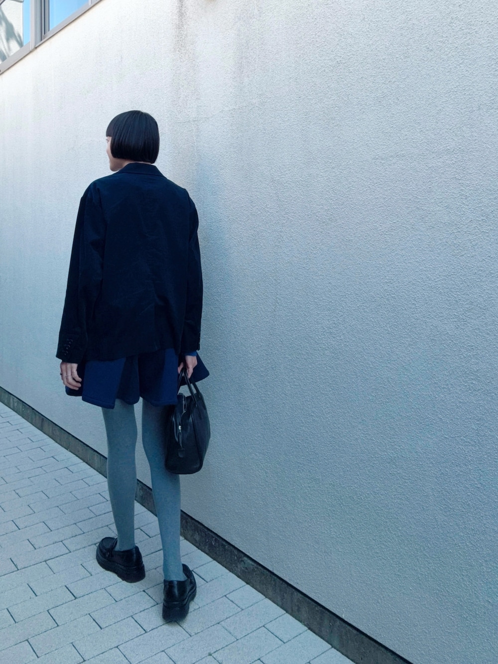 ブラック系のパンプス、ブルー系のパンツ、ブルー系のスウェットを着用したレディースの春コーディネートの2枚目の写真