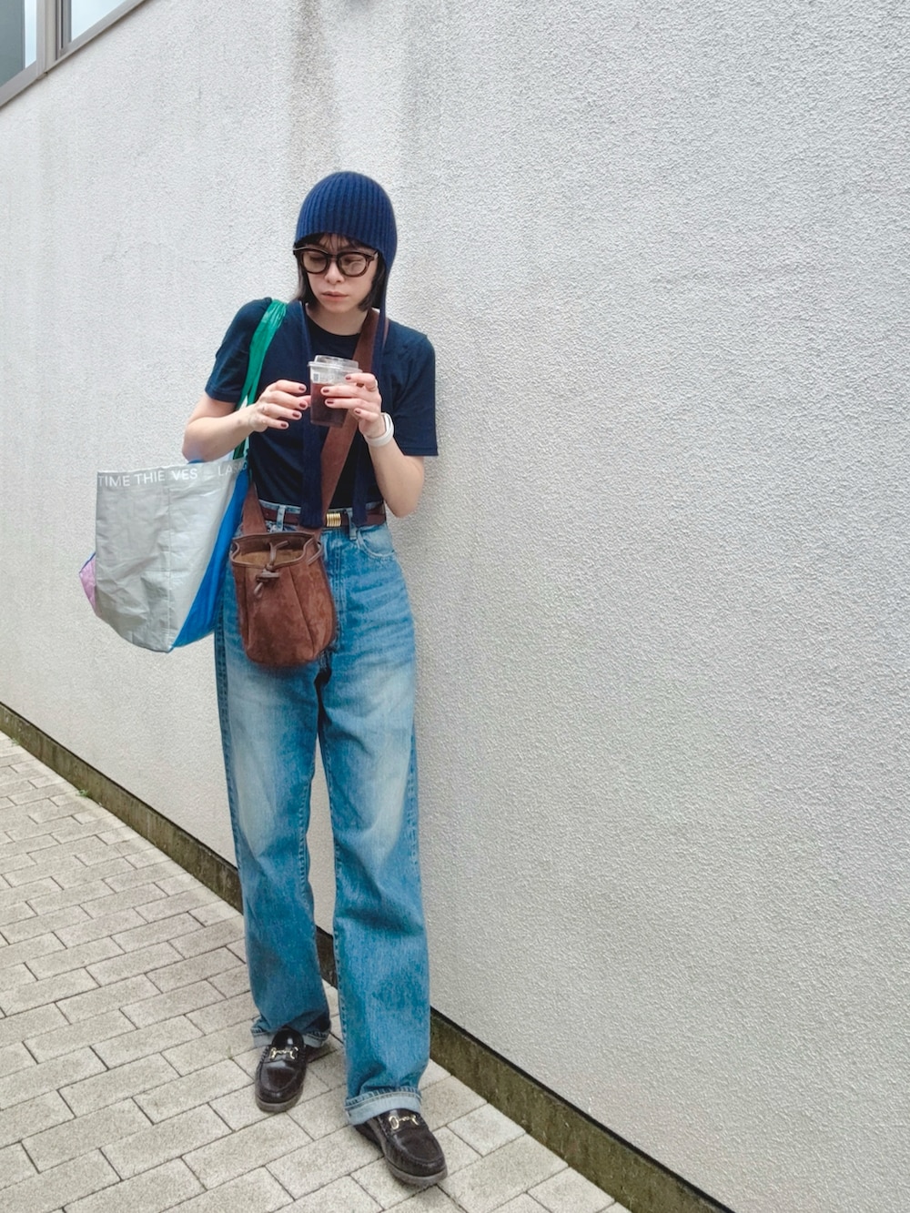 ブルー系のデニムパンツ、ブルー系のTシャツ/カットソー、ブラウン系のバッグを着用したレディースの秋コーディネートの3枚目の写真