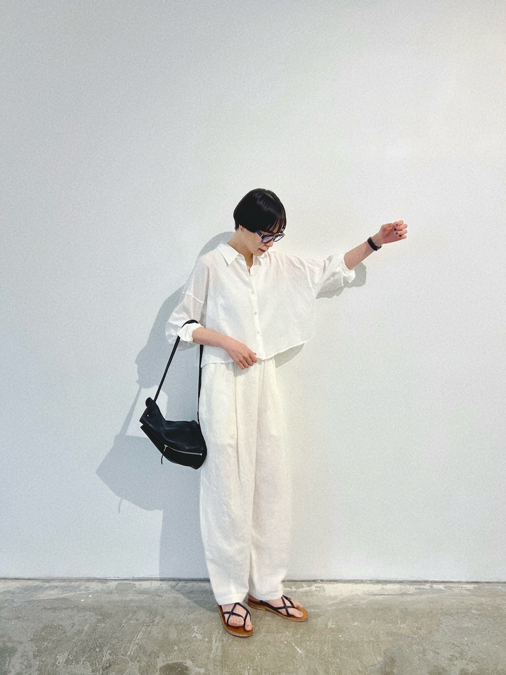 ホワイト系のシャツ/ブラウス、ホワイト系のパンツ、ブラック系のバッグを着用したレディースの夏コーディネートの2枚目の写真