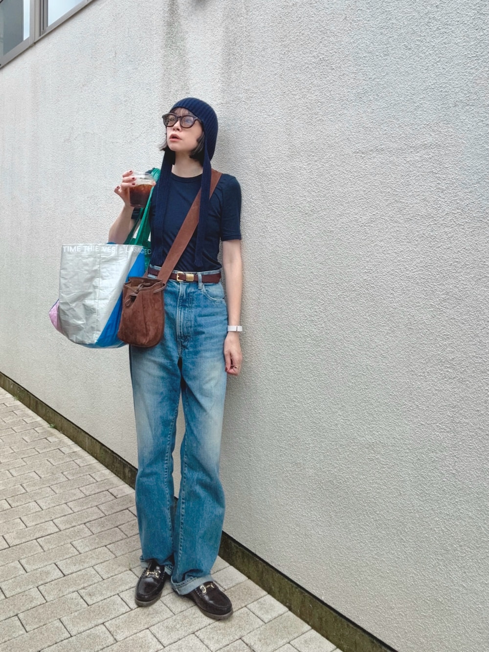 ブルー系のデニムパンツ、ブルー系のTシャツ/カットソー、ブラウン系のバッグを着用したレディースの秋コーディネートの2枚目の写真