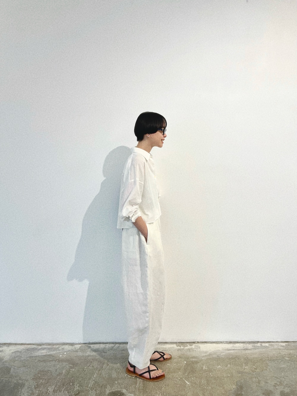 ホワイト系のシャツ/ブラウス、ホワイト系のパンツ、ブラック系のバッグを着用したレディースの夏コーディネートの3枚目の写真