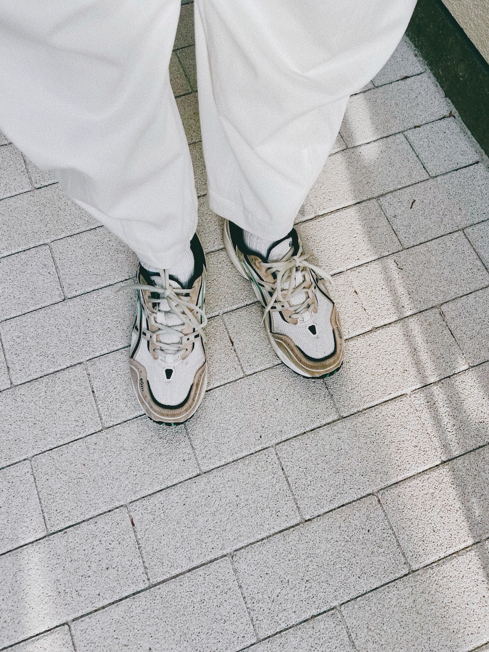 ホワイト系のパンツ、ブラック系のシャツ/ブラウス、ベージュ系のスニーカーを着用したレディースの春コーディネートの2枚目の写真