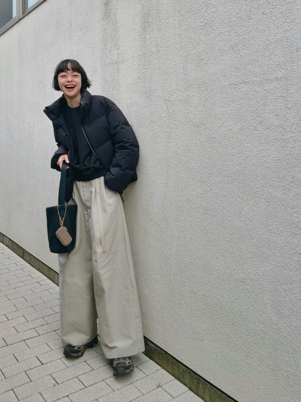 グレー系のスニーカー、ブラック系のダウンジャケット/コート、ブラック系のブルゾンを着用したレディースの冬コーディネートの2枚目の写真