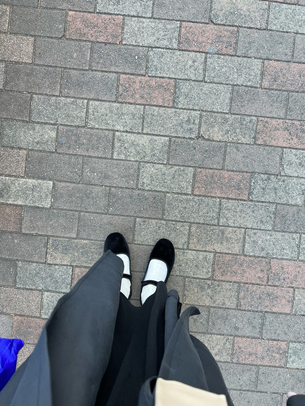 ブラック系のワンピース、ブラック系のステンカラーコート、ブラック系のバレエシューズを着用したレディースの冬コーディネートの2枚目の写真