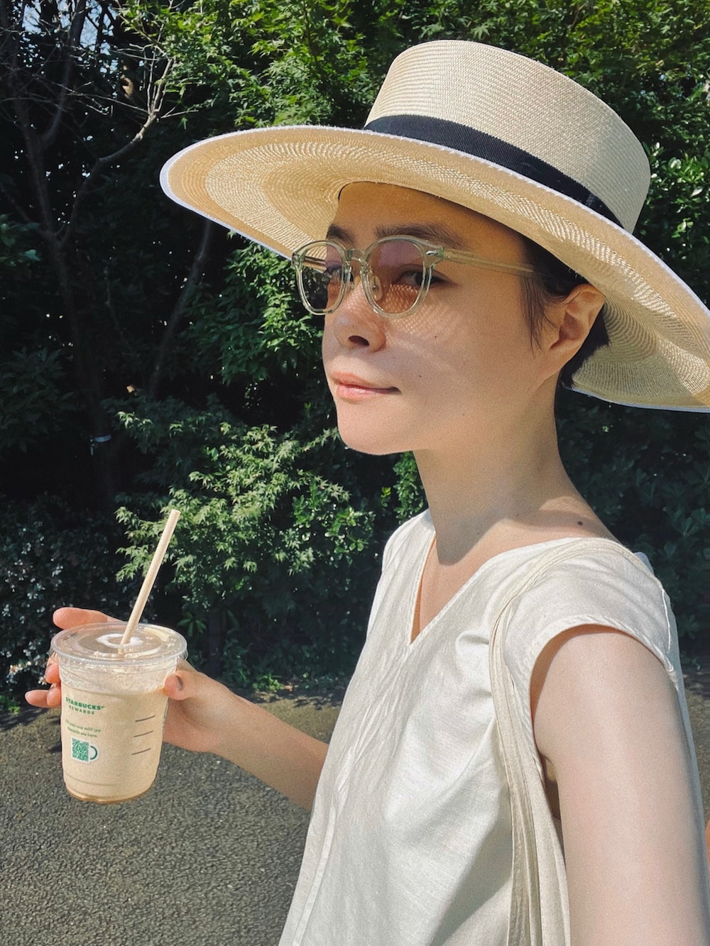 ホワイト系のシャツ/ブラウス、ベージュ系のパンツ、ブラック系のサンダルを着用したレディースの夏コーディネートの3枚目の写真