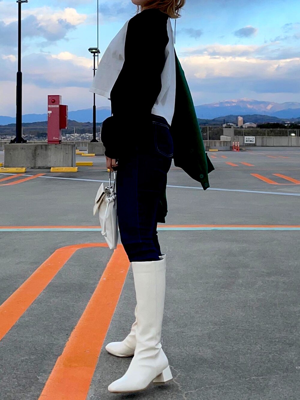 ホワイト系のブーツ、ブルー系のデニムパンツ、ブラック系のカーディガン/ボレロを着用したレディースの冬コーディネートの4枚目の写真