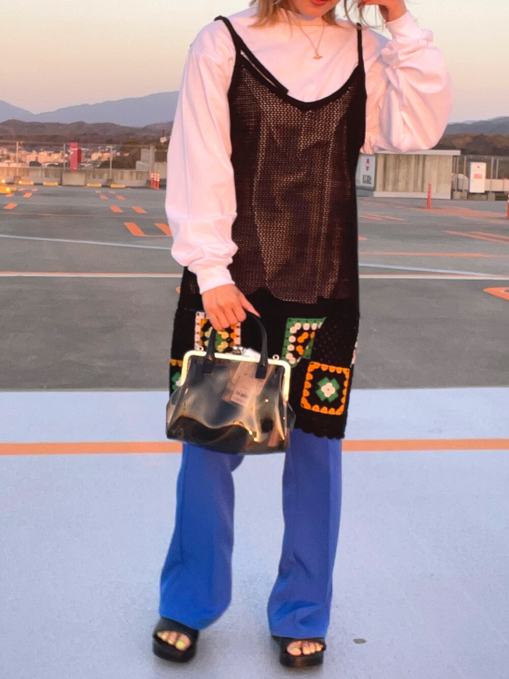 ブラック系のサンダル、ブルー系のスラックス、ブラック系のワンピースを着用したレディースの春コーディネートの5枚目の写真