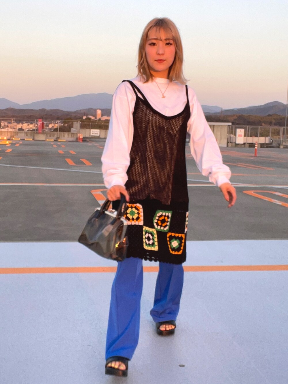 ブラック系のサンダル、ブルー系のスラックス、ブラック系のワンピースを着用したレディースの春コーディネートの4枚目の写真