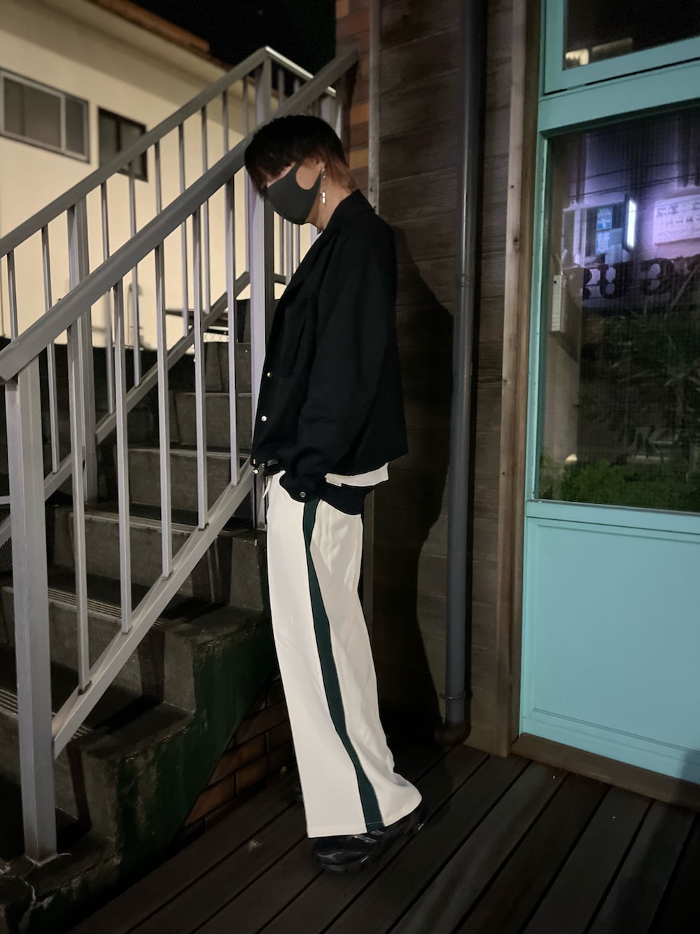 ホワイト系のスラックス、ブラック系のスニーカー、ブラック系のタンクトップを着用したメンズの秋コーディネートの5枚目の写真