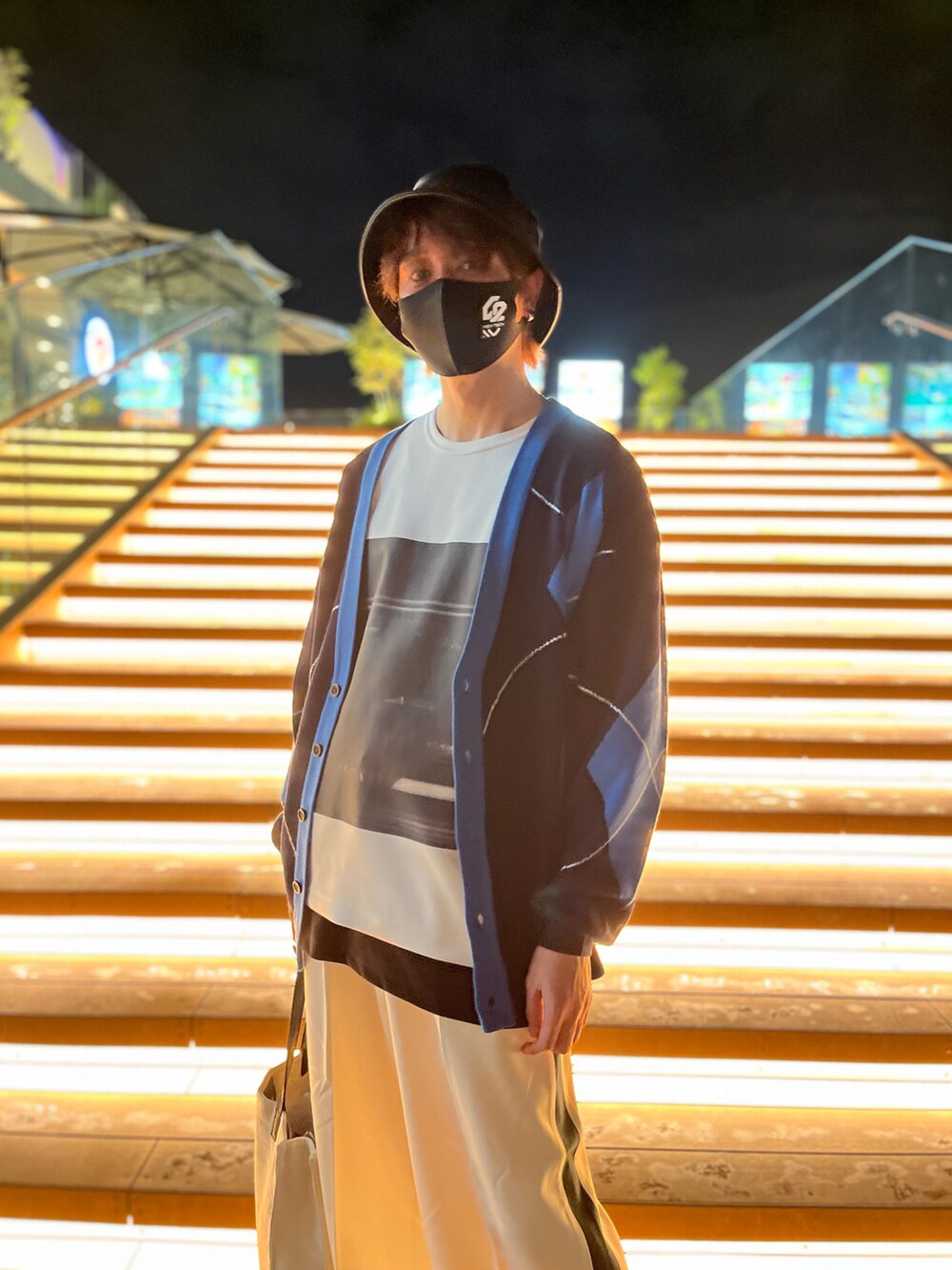 ブルー系のスニーカー、ホワイト系のトートバッグ、ブルー系のカーディガン/ボレロを着用したメンズの秋コーディネートの3枚目の写真