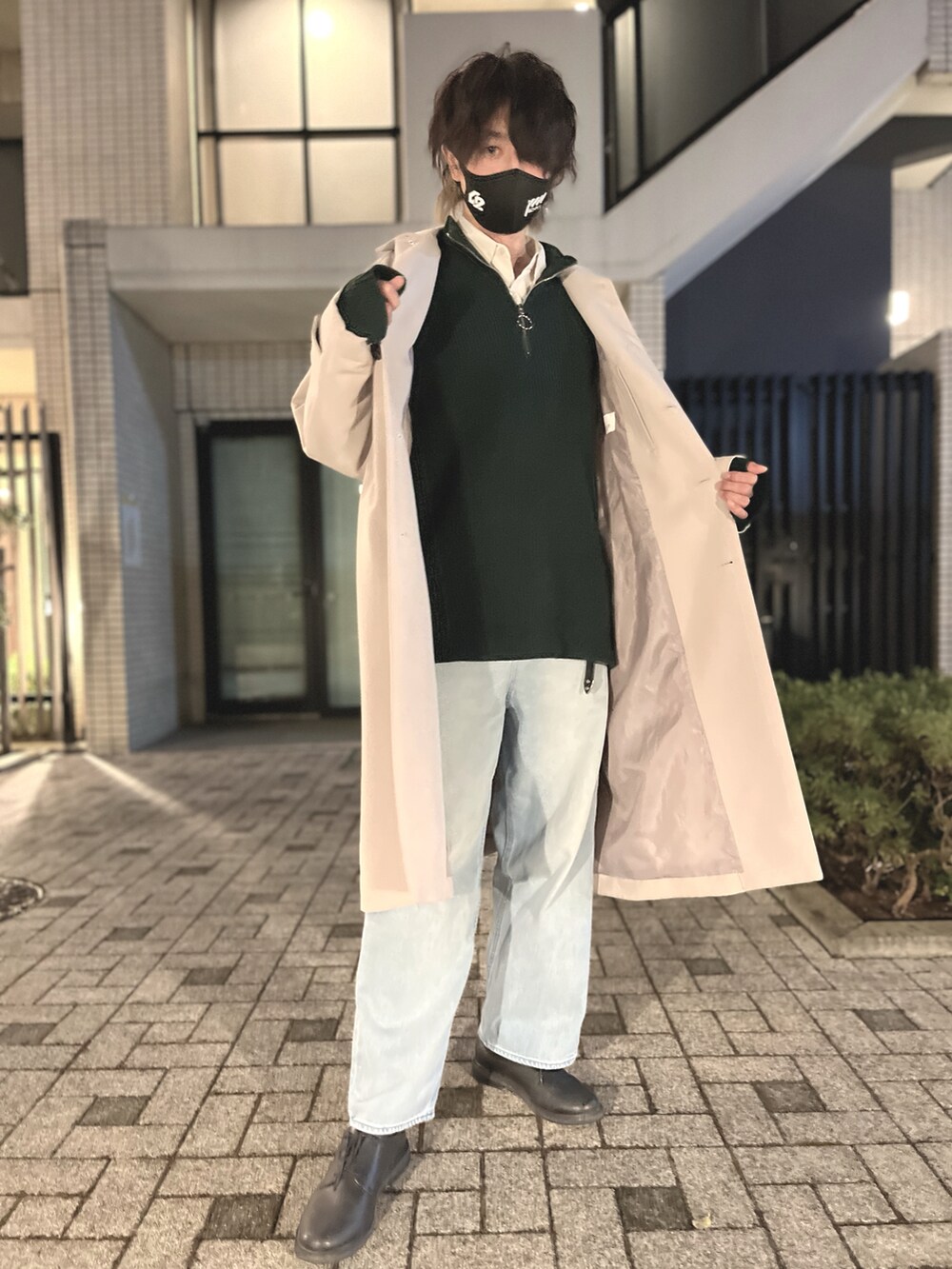 グリーン系のニット/セーター、ブラック系のタンクトップ、ベージュ系のステンカラーコートを着用したメンズの冬コーディネートの5枚目の写真