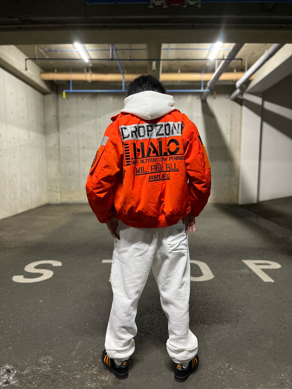 ホワイト系のスウェットパンツ、ホワイト系のパーカー、オレンジ系のMA-1を着用したメンズの冬コーディネートの4枚目の写真