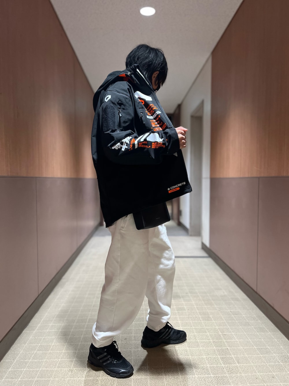 ホワイト系のスウェットパンツ、ブラック系のスニーカー、ブラック系のショルダーバッグを着用したメンズの冬コーディネートの3枚目の写真