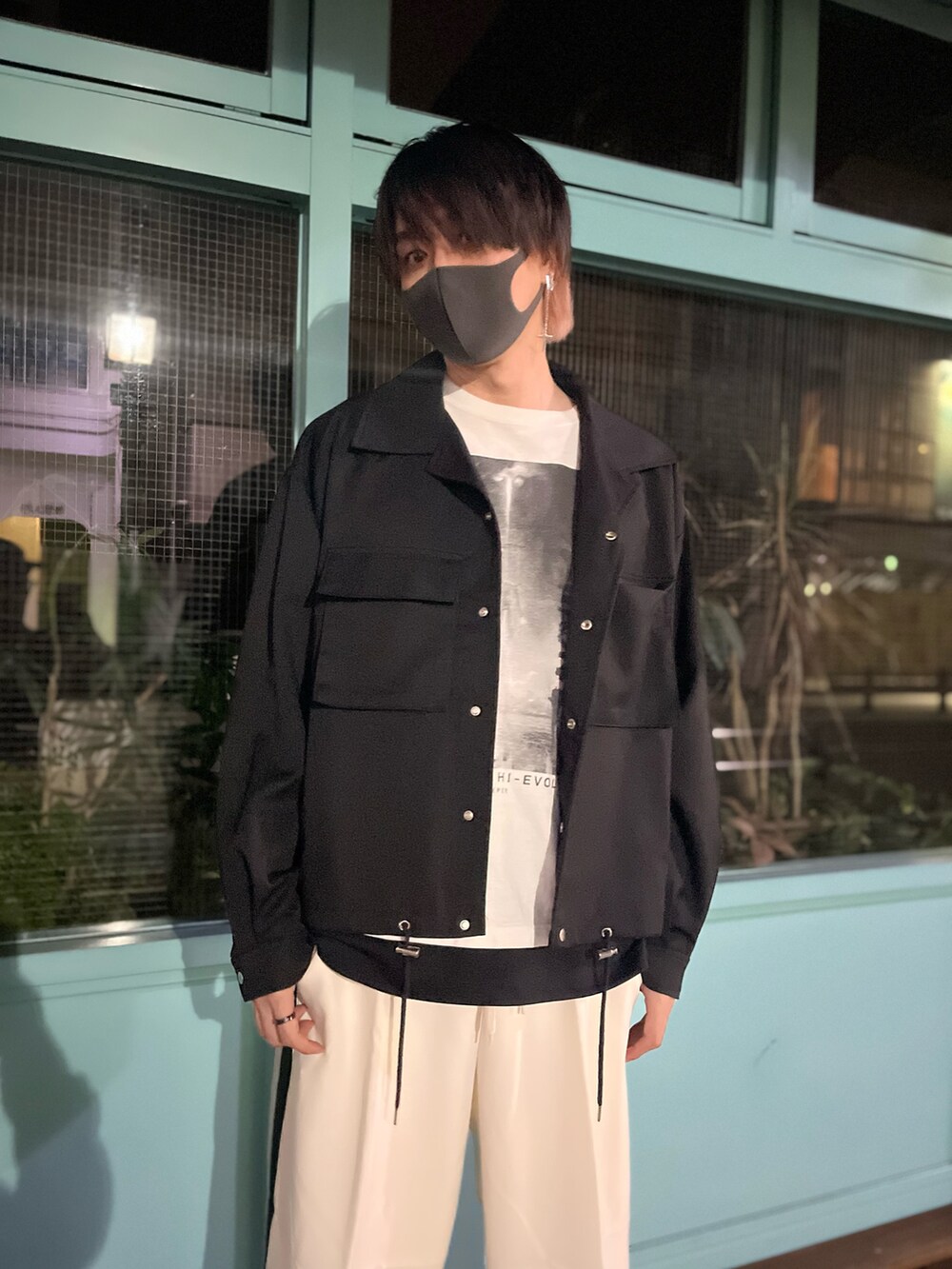 ホワイト系のスラックス、ブラック系のスニーカー、ブラック系のタンクトップを着用したメンズの秋コーディネートの4枚目の写真