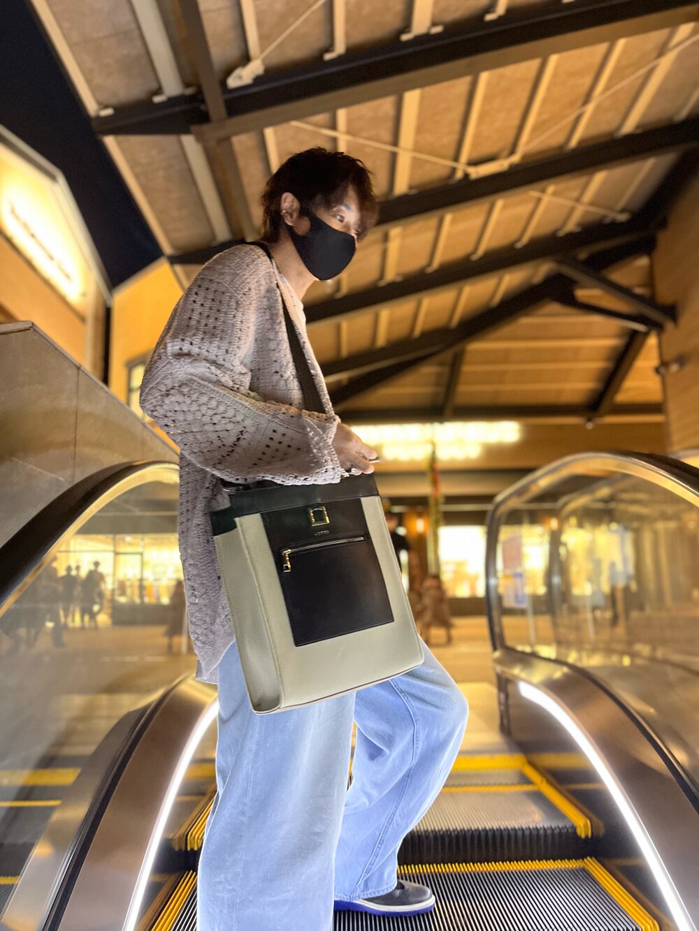 ベージュ系のトートバッグ、ベージュ系のカーディガン/ボレロ、ホワイト系のTシャツ/カットソーを着用したメンズの秋コーディネートの5枚目の写真