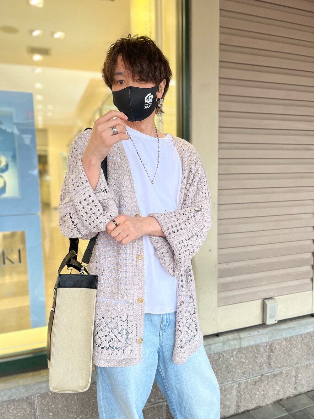 ベージュ系のトートバッグ、ベージュ系のカーディガン/ボレロ、ホワイト系のTシャツ/カットソーを着用したメンズの秋コーディネートの3枚目の写真