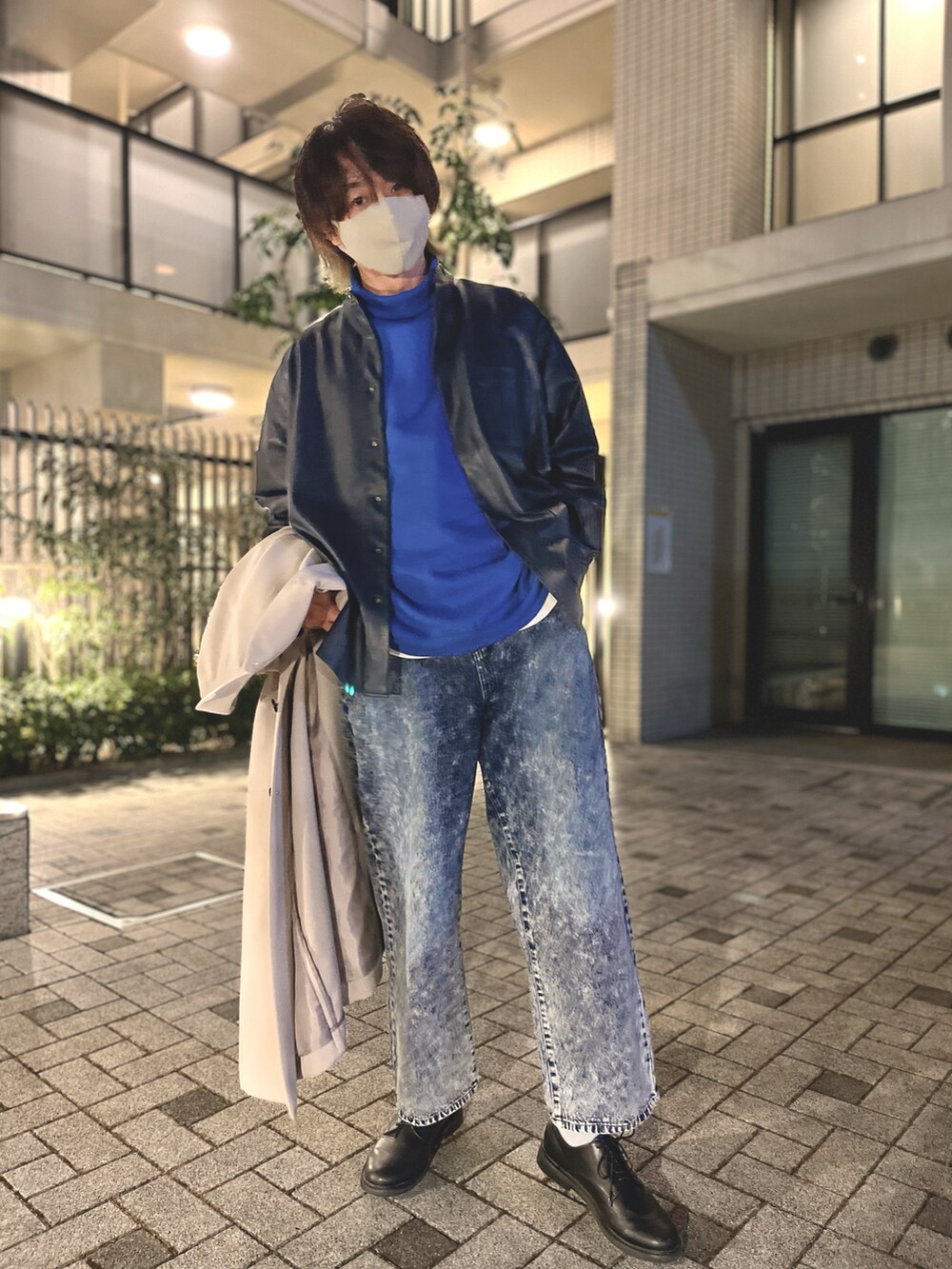 ブルー系のニット/セーター、ホワイト系のタンクトップ、ベージュ系のステンカラーコートを着用したメンズの冬コーディネートの2枚目の写真
