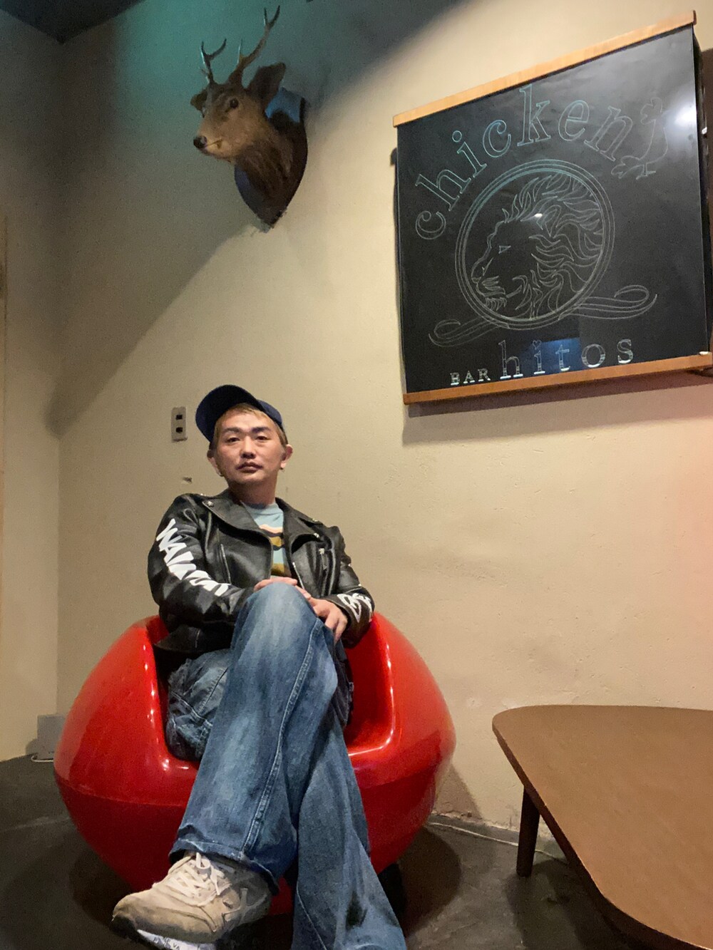 ブラック系のライダースジャケット、ブルー系のデニムパンツ、シルバー系のスニーカーを着用したメンズの秋コーディネートの2枚目の写真