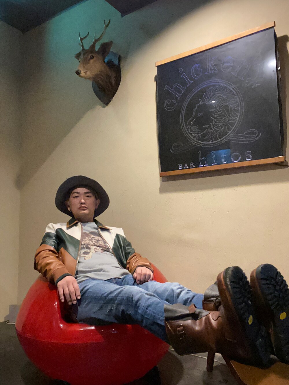 ブルー系のデニムパンツ、ブラウン系のブーツ、ブラウン系のブルゾンを着用したメンズの秋コーディネートの3枚目の写真