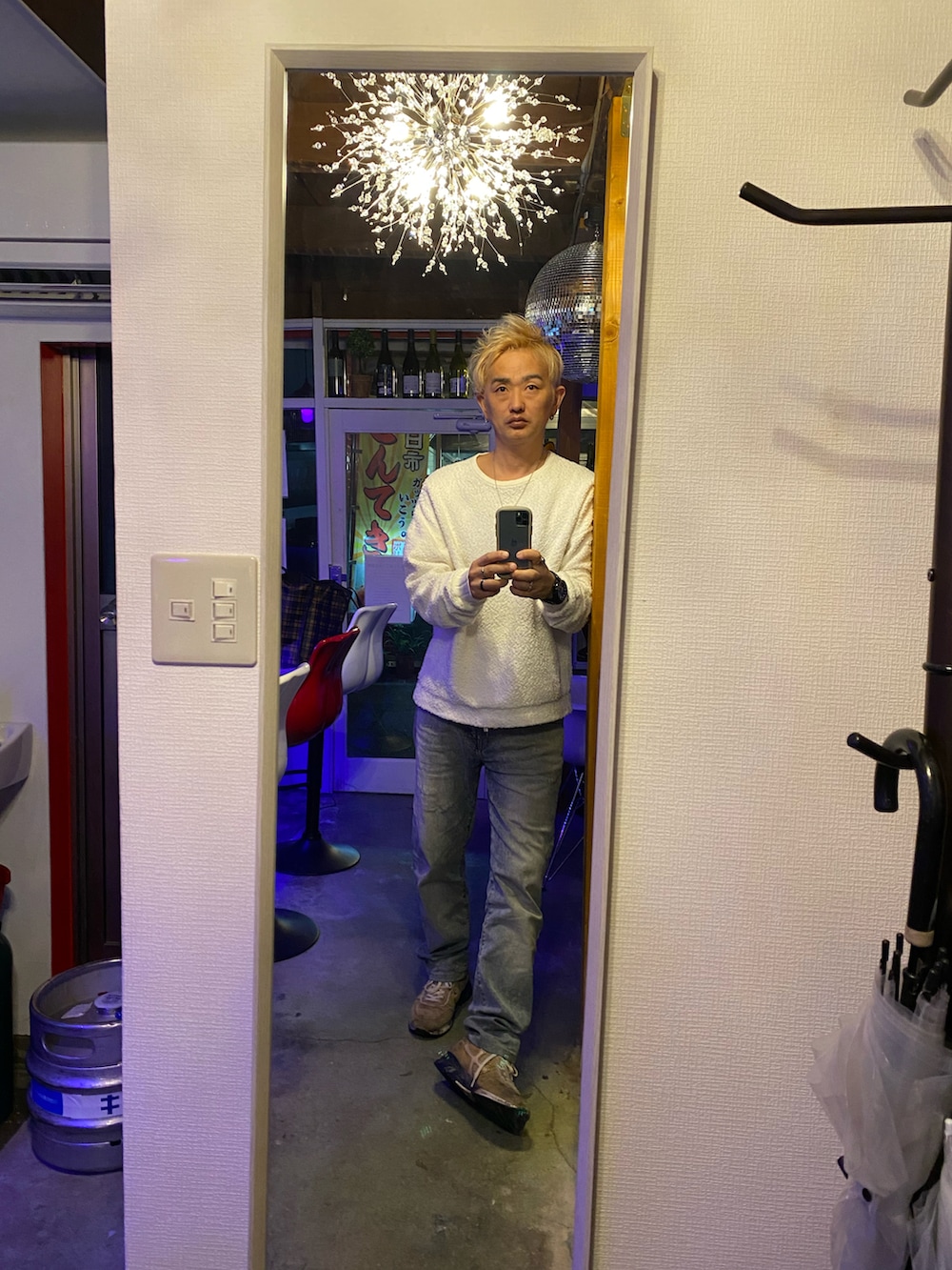 ホワイト系のTシャツ/カットソー、グリーン系のナイロンジャケット、ブルー系のデニムパンツを着用したメンズの冬コーディネートの2枚目の写真