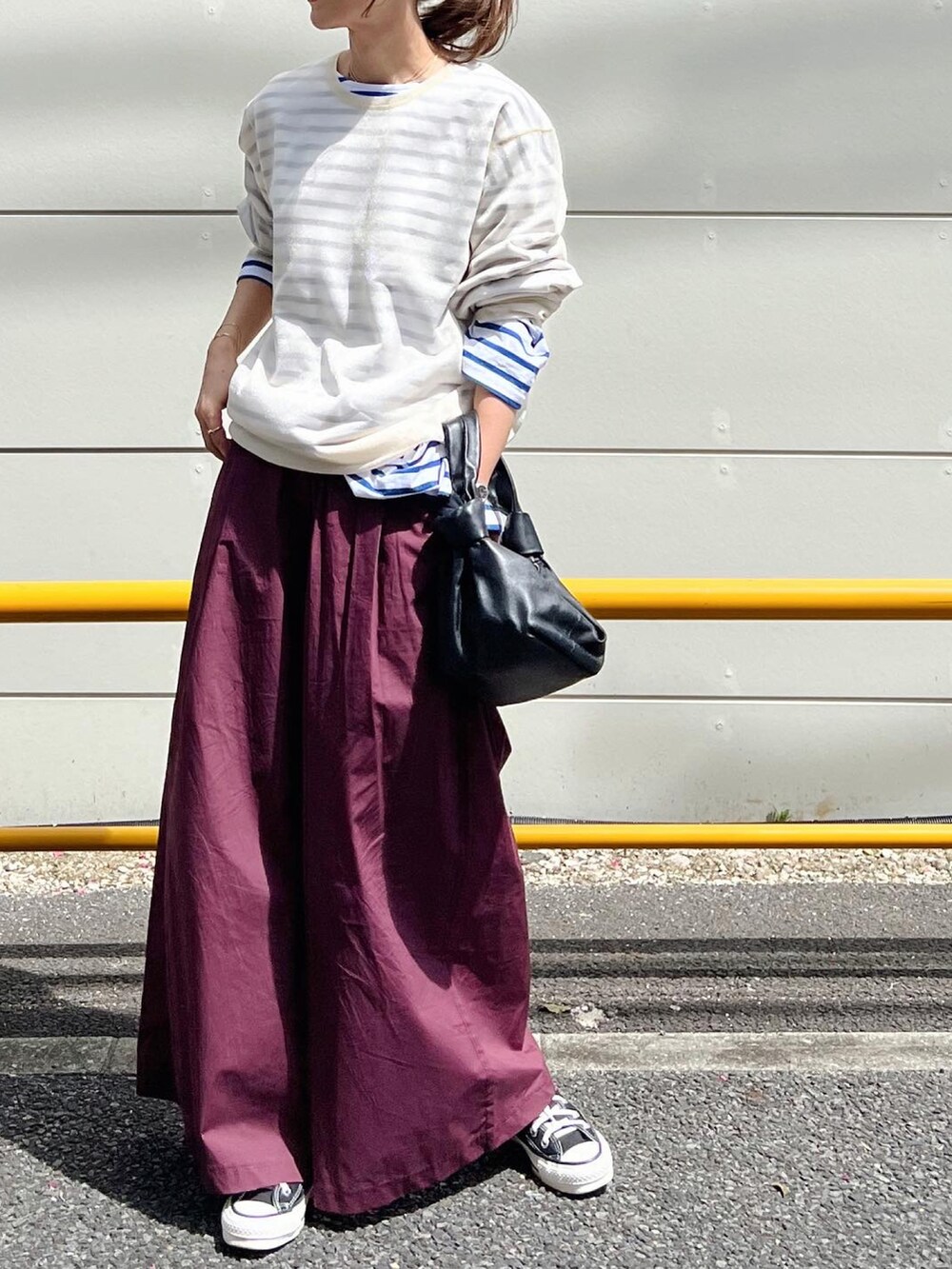 レッド系のその他パンツ、ブラック系のバッグ、グリーン系のスニーカーを着用したレディースの春コーディネートの3枚目の写真