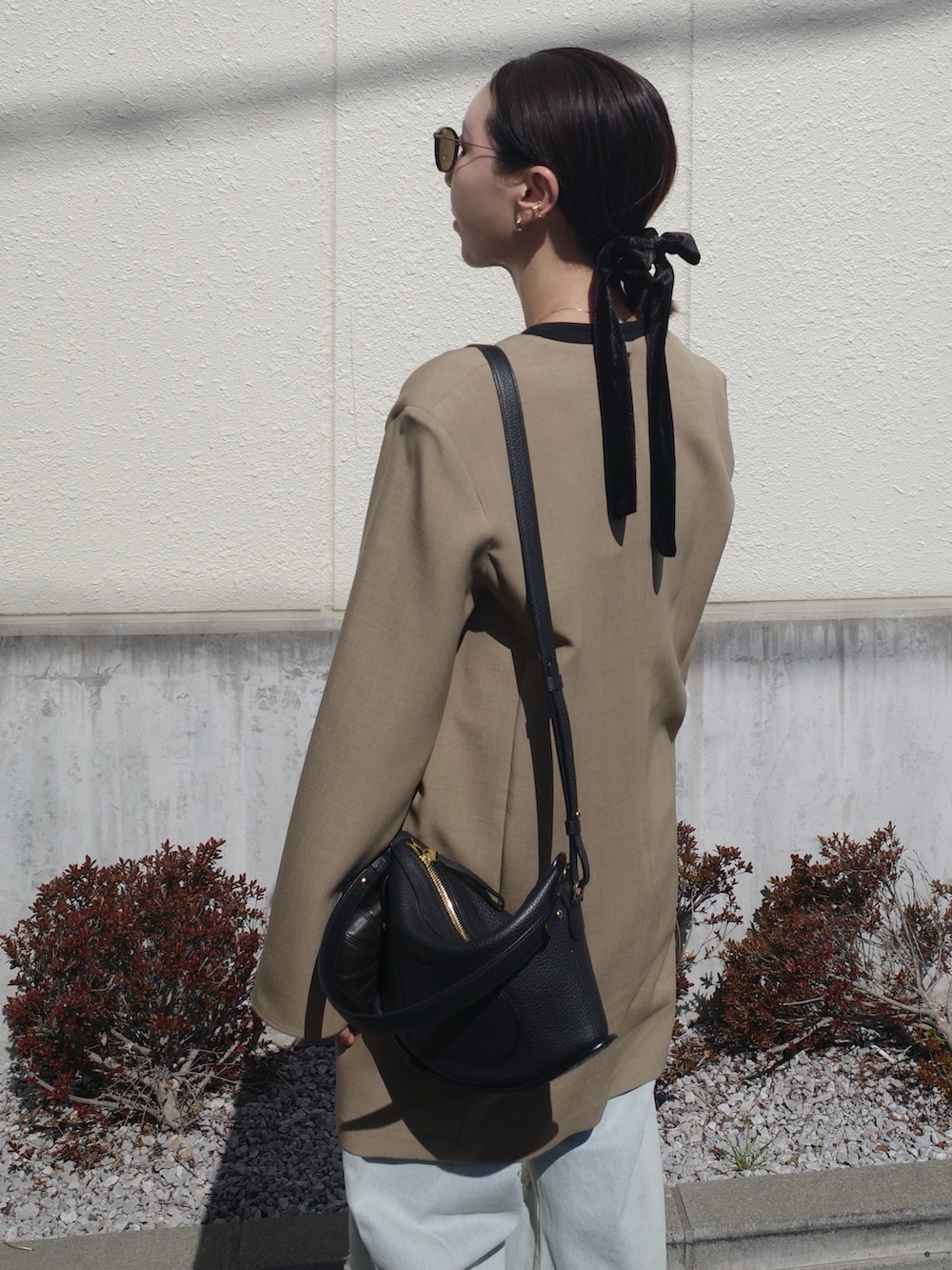 ブラック系のブーツ、ベージュ系のワンピース、ブラック系のバッグを着用したレディースの春コーディネートの5枚目の写真