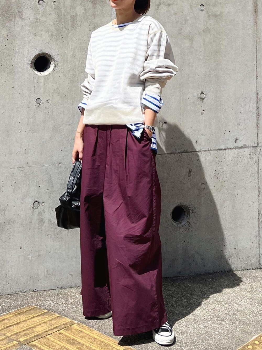 レッド系のその他パンツ、ブラック系のバッグ、グリーン系のスニーカーを着用したレディースの春コーディネートの4枚目の写真